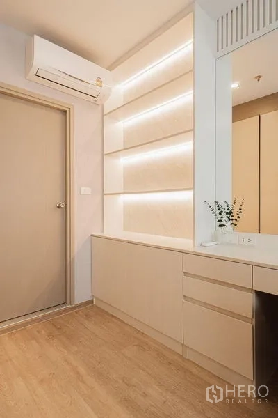 Condominium for rent - Close-up of illuminated built-in shelves and storage in soft neutral tones.