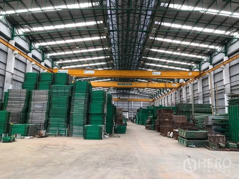 工厂 出租或出售在Lat Lum Kaeo, Pathum Thani - 大型厂房内部，高净空屋顶、行车吊与有序的物料货架。