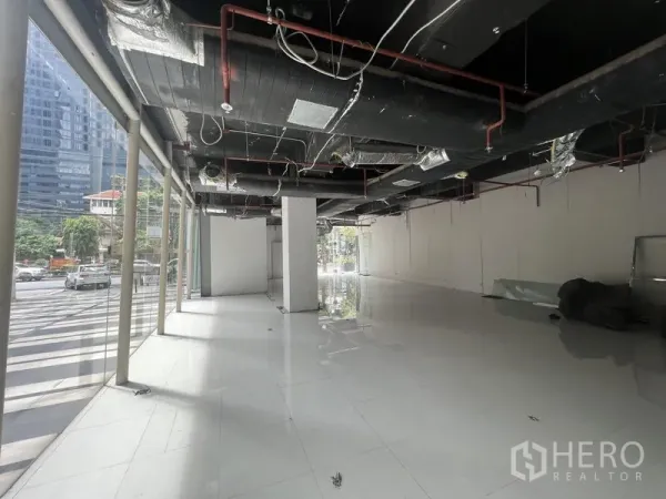 零售空间 出租在Watthana, Bangkok - 零售铺位毛坯内景，落地窗、亮面地砖与外露管线天花。