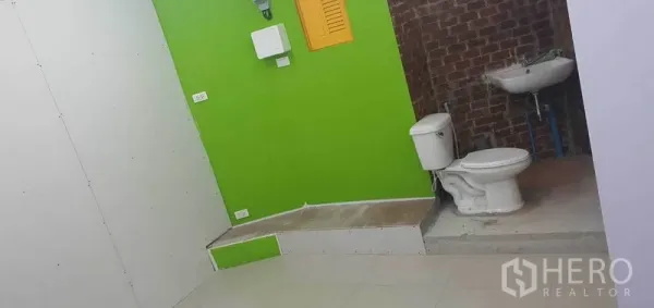 พื้นที่ขายปลีก ให้เช่าในKhlong Toei, Bangkok - ห้องน้ำขนาดเล็กพร้อมโถสุขภัณฑ์ อ่างล้างหน้า ผนังสีเขียวสดและอิฐโชว์แนว