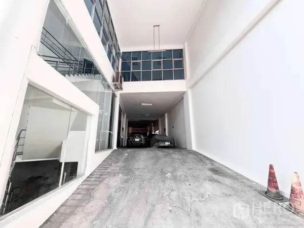 展厅 出租或出售在Bangkok Yai, Bangkok - 带顶车道直入建筑，旁侧为玻璃立面与可见的楼梯。