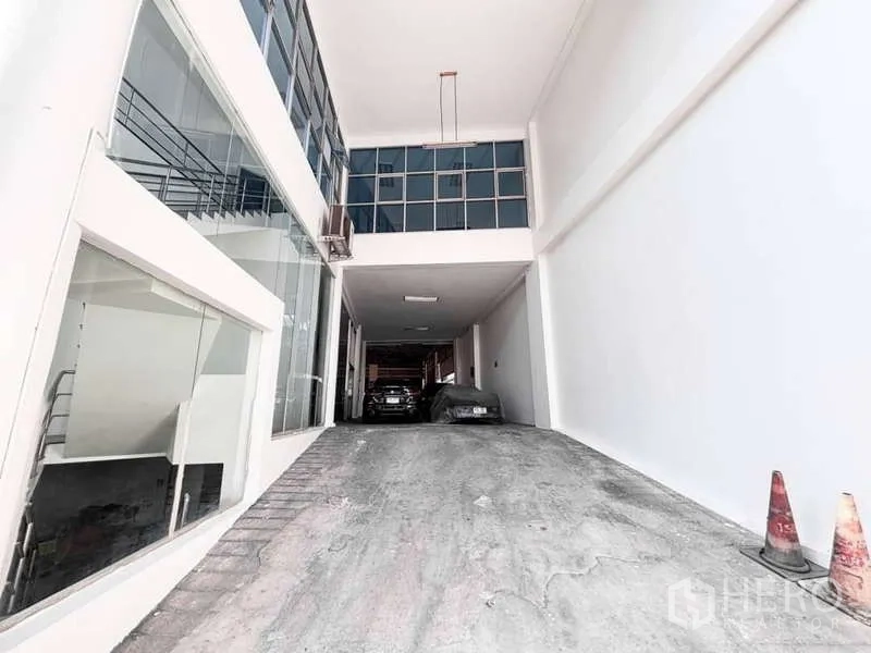 展厅 出租或出售在Bangkok Yai, Bangkok - 带顶车道直入建筑，旁侧为玻璃立面与可见的楼梯。