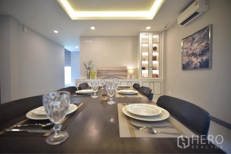 Detached House for rent in Bang Phli, Samut Prakan - Close-up of dining table set for six under tray ceiling lighting.