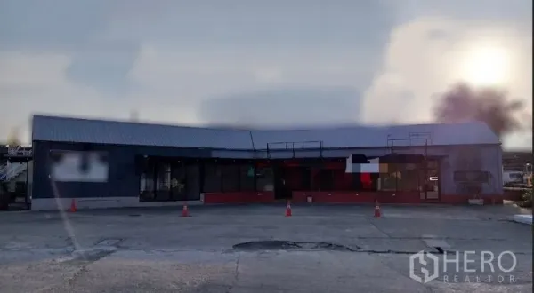 Retail Space for rent in Khlong Toei, Bangkok - Single-storey retail unit with metal roof, wide glass frontage, and spacious forecourt parking near BTS Phra Khanong.