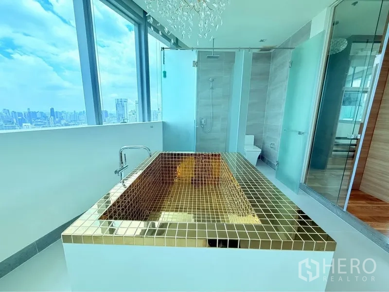 คอนโด ให้เช่าหรือขายในKhlong Toei, Bangkok - ห้องน้ำมาสเตอร์ อ่างอาบน้ำกระเบื้องโมเสกสีทองข้างกระจกสูงและตู้ฝักบัว