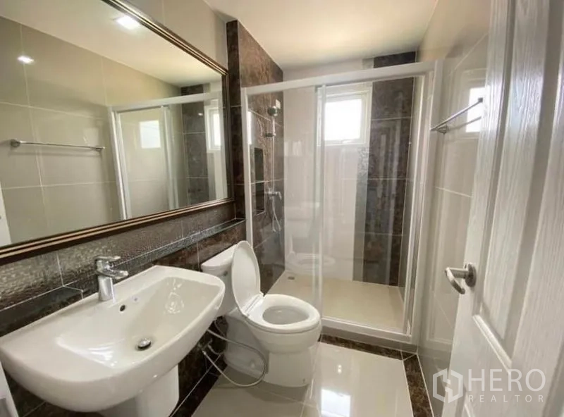 Detached House for rent or sale - Modern bathroom with glass-enclosed shower, large mirror and white sanitary ware.
