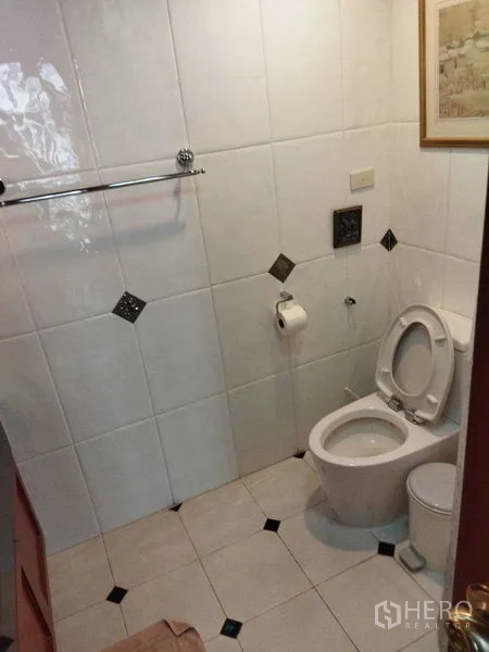 คอนโด ให้เช่าในPathum Wan, Bangkok - ห้องน้ำปูกระเบื้องสีขาวพร้อมโถสุขภัณฑ์ ราวผ้า และลายกระเบื้อง