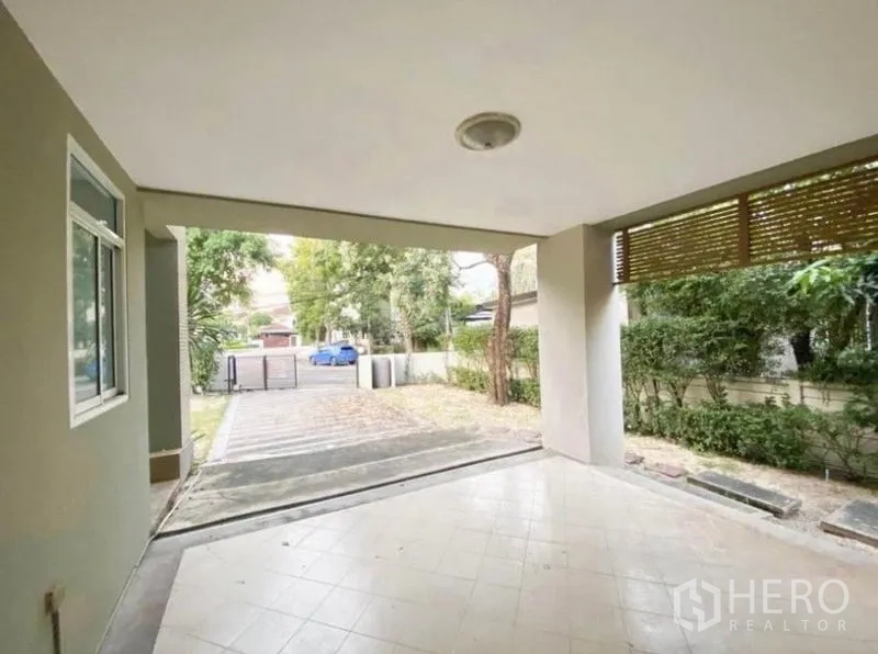 บ้าน ขายในSaphan Sung, Bangkok - ที่จอดรถในร่มและเฉลียง มองออกไปยังทางรถและแนวรั้วพุ่มไม้