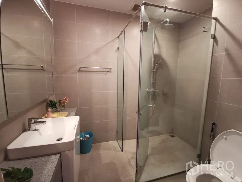 คอนโด ให้เช่าในPathum Wan, Bangkok - ห้องน้ำโทนอบอุ่น พร้อมตู้กระจกอาบน้ำและอ่างล้างหน้า