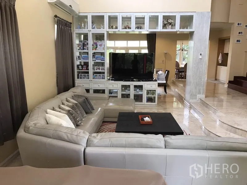 独立式住宅 出租 - 客厅望向电视柜与台阶上方的餐区，真石地面光亮。