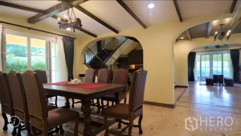 Detached House for rent or sale in Bang Phli, Samut Prakan - Open-plan dining area with eight-seat table, arched openings and a view to the staircase and lounge.