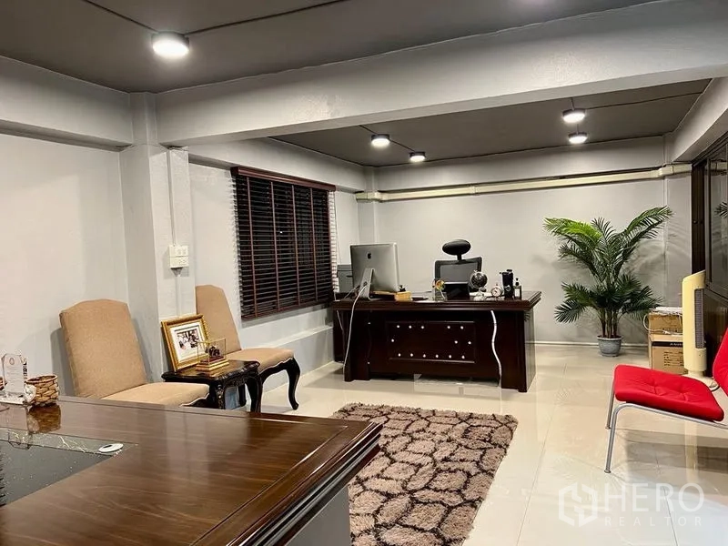 Shophouse for sale in Bang Kho Laem, Bangkok - Executive office room with dark wood desk, seating and plants.