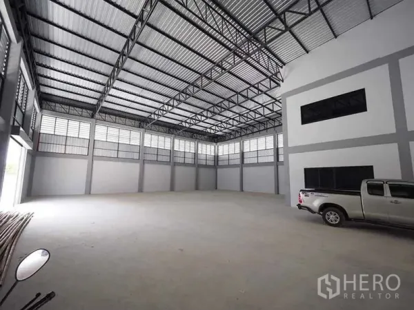 Warehouse for rent or sale in Krathum Baen, Samut Sakhon - High-clear warehouse bay with ample natural light and a pickup truck parked inside.