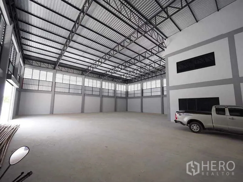 Warehouse for rent or sale in Krathum Baen, Samut Sakhon - High-clear warehouse bay with ample natural light and a pickup truck parked inside.