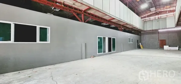 Warehouse for rent in Chatuchak, Bangkok - Spacious warehouse interior with high roof, steel trusses, concrete floor and built-in office rooms with windows.