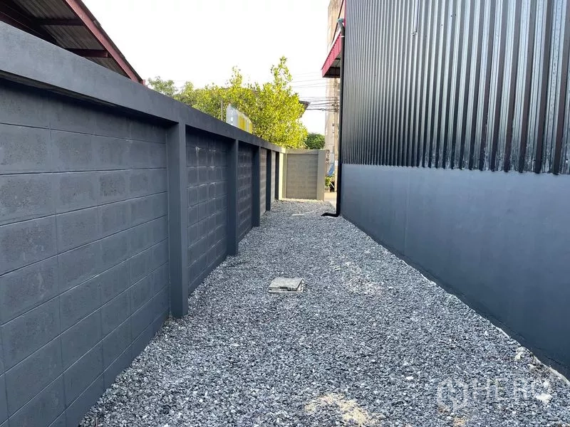 คลังสินค้า ให้เช่าในBang Kapi, Bangkok - ทางเดินโรยหินระหว่างกำแพงคอนกรีตสูงกับผนังเมทัลชีทของโกดัง