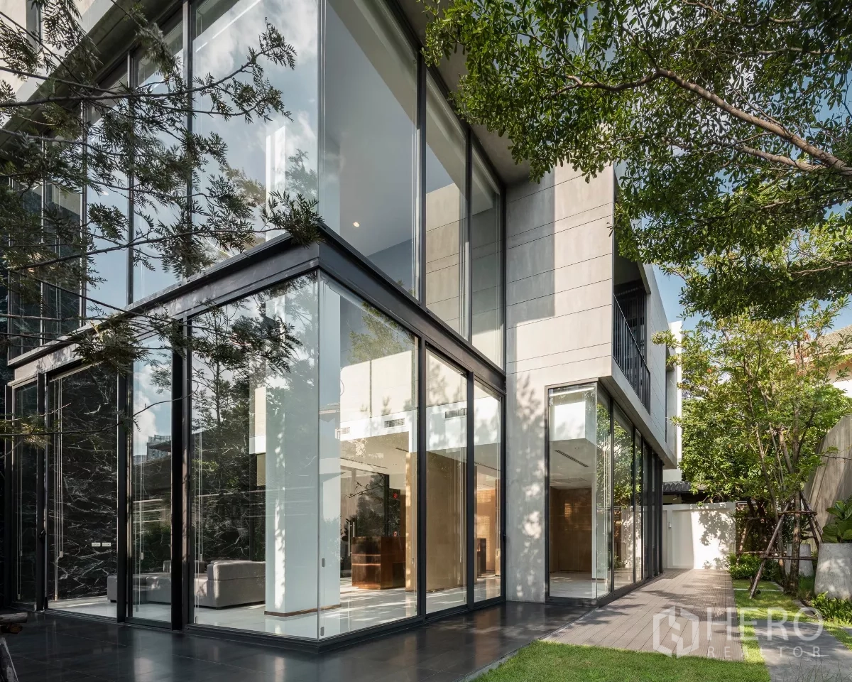 Condominium for rent in Bang Kapi, Bangkok - Contemporary condominium exterior with double-height glass lobby opening to landscaped garden.
