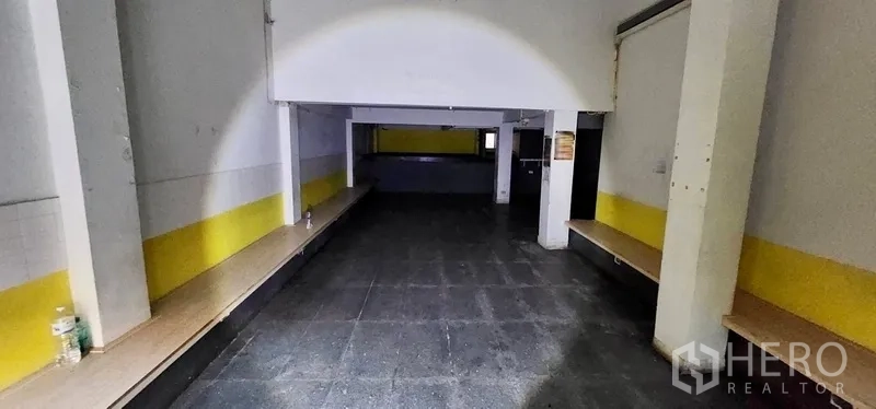 สำนักงานที่บ้าน ให้เช่าในSathon, Bangkok - พื้นที่ชั้นล่างแบบโอเพ่นแปลน พื้นสีเข้ม มีเสาตรงกลางและเคาน์เตอร์ยาวตามผนัง