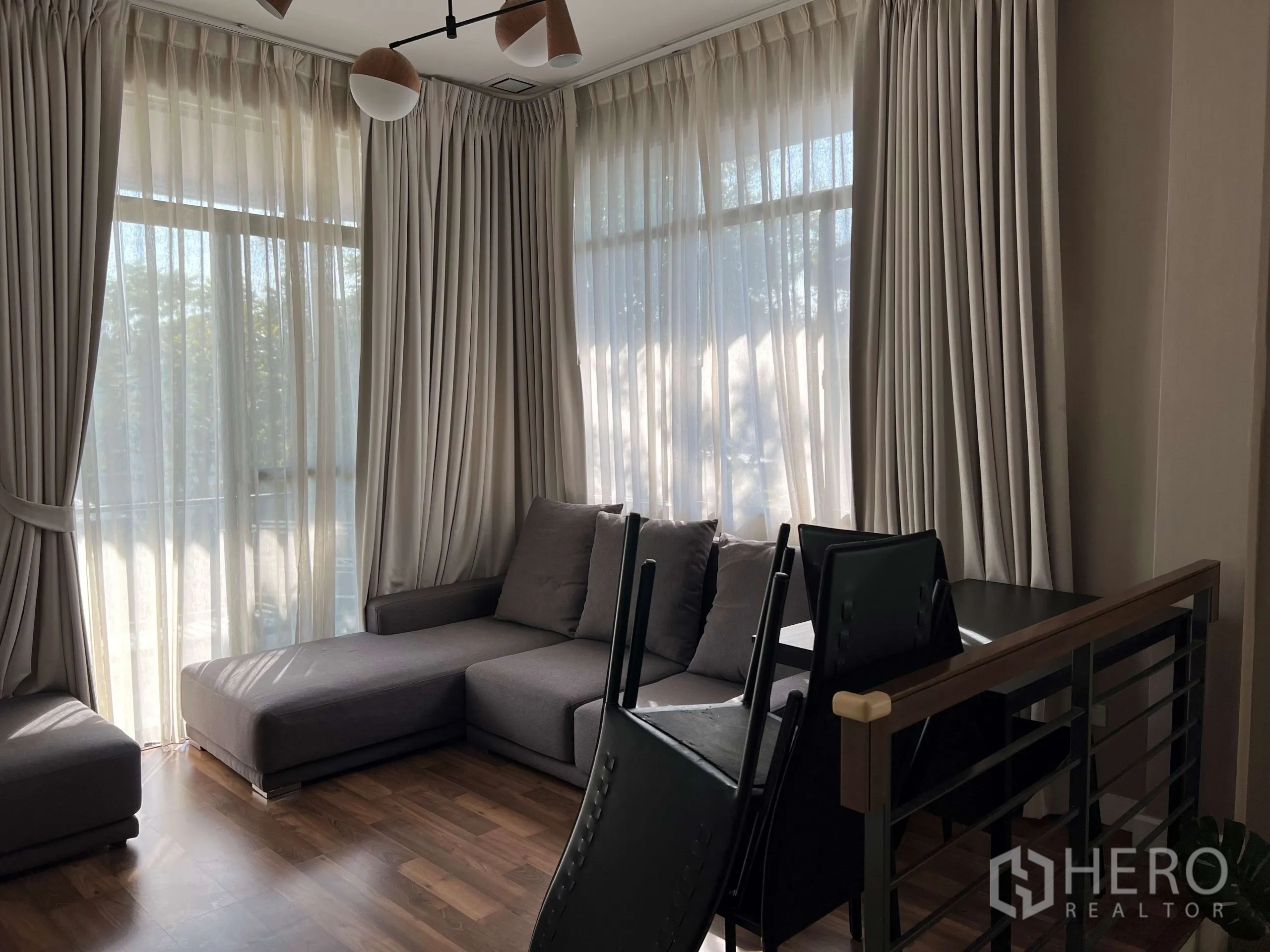 Detached House for rent in Prawet, Bangkok - Upstairs family lounge with sectional sofa and full-height sheer curtains.