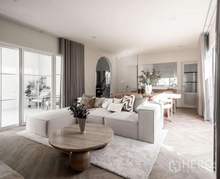 Detached House for rent or sale in Bang Phli, Samut Prakan - Bright living room with L-shaped sofa, round coffee table and large windows.
