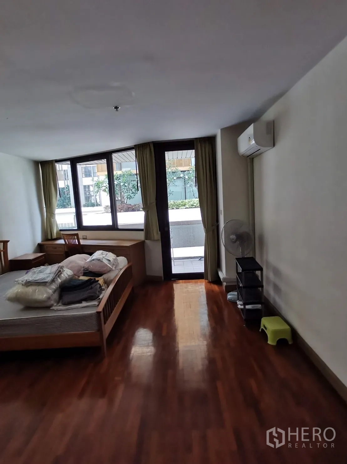 คอนโด ให้เช่าในPathum Wan, Bangkok - มุมกว้างของห้องนอนเห็นประตูออกเทอเรซ โต๊ะทำงานริมหน้าต่าง และเครื่องปรับอากาศติดผนัง