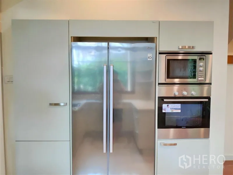 独立式住宅 出租在Watthana, Bangkok - 一体化橱柜特写，内置对开门冰箱、微波炉与电烤箱。