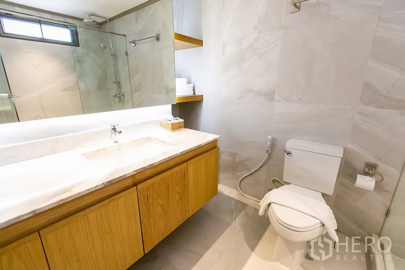 อพาร์ทเมนท์ ให้เช่าในKhlong Toei, Bangkok - ห้องน้ำพร้อมกระจกไฟซ่อน โต๊ะเคาน์เตอร์หินอ่อน และชั้นเก็บของ