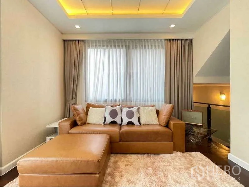 Detached House for rent in Bang Sue, Bangkok - Upper lounge with leather sofa, ottoman and soft rug.