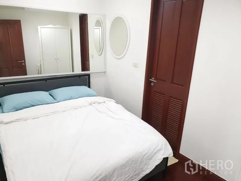 คอนโด ให้เช่าหรือขายในPathum Wan, Bangkok - ห้องนอนที่สองเตียงดับเบิล กระจกเงาบนผนัง ประตูไม้ และผนังสีขาว