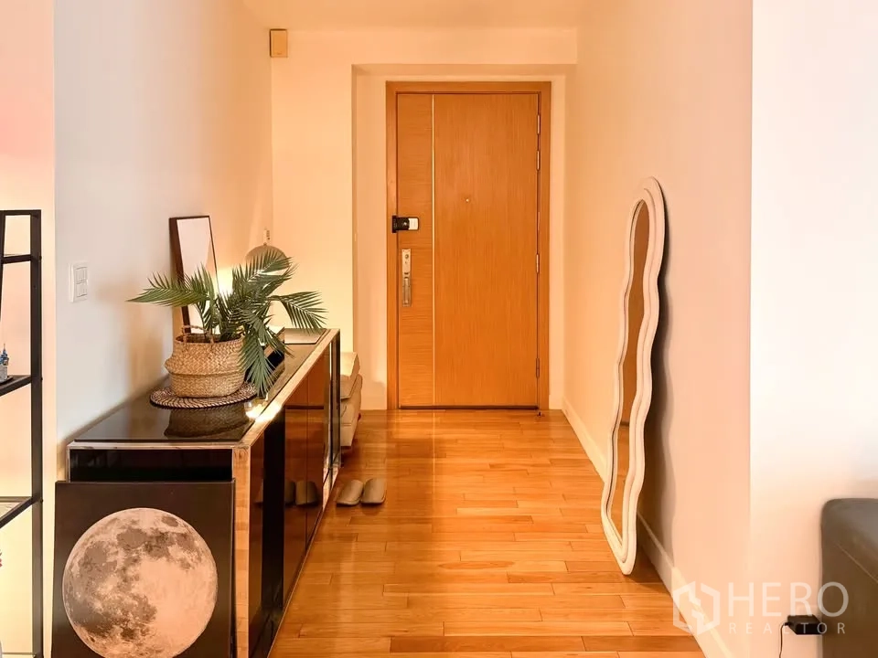 คอนโด for rent or sale in Khlong Toei, Bangkok - โถงทางเข้าพื้นไม้ ประตูไม้ ตู้คอนโซล และกระจกเงาตกแต่ง