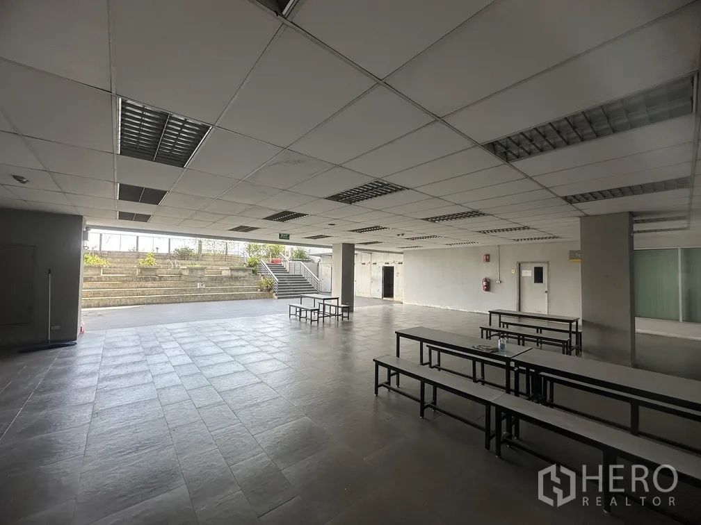 Factory for rent in Lam Luk Ka, Pathum Thani - Canteen hall facing outdoor amphitheater-style steps and planters.