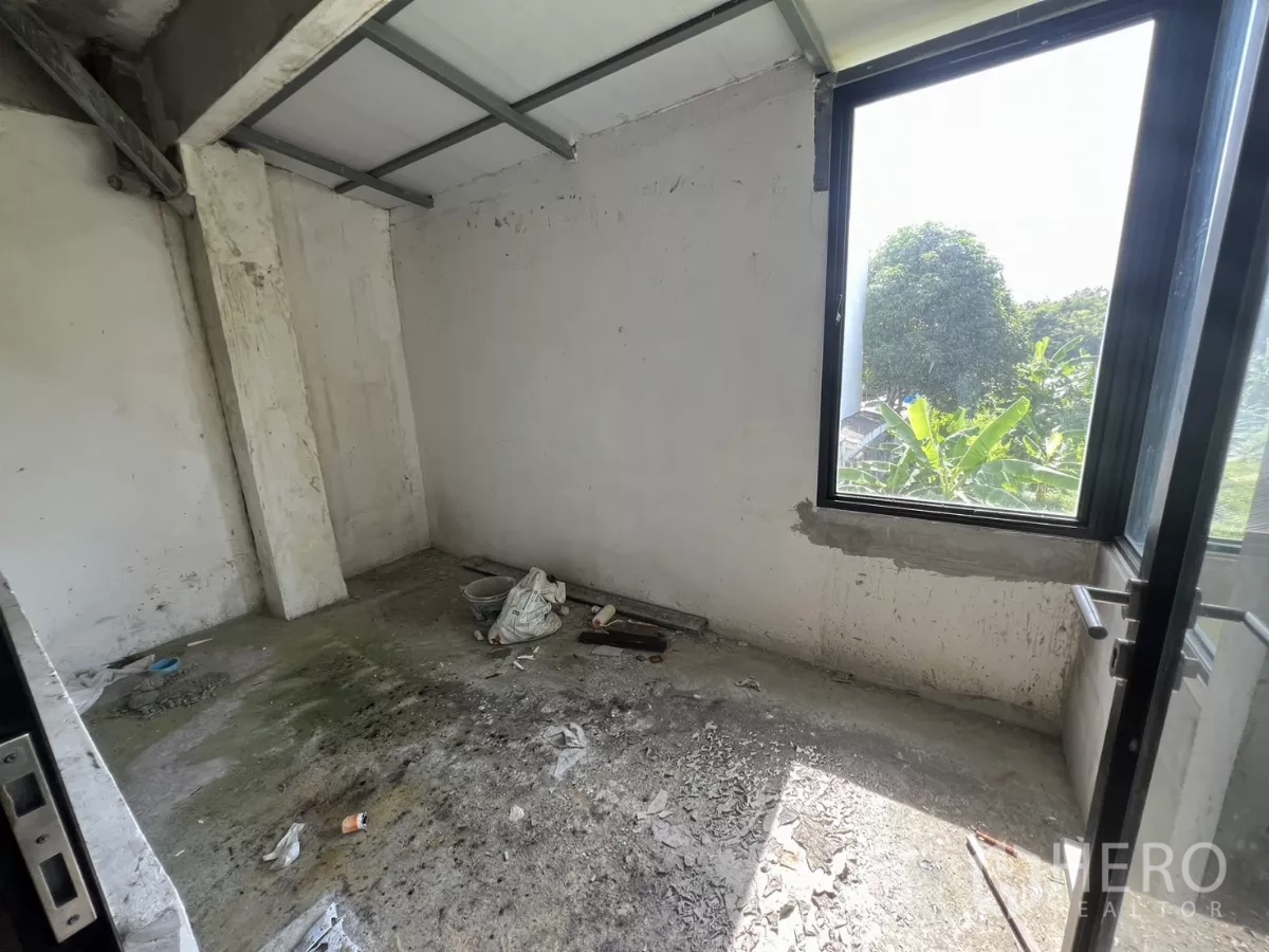 店屋 出售在Suan Luang, Bangkok - 小型未完工房间，单窗与地面施工残料可见。