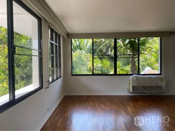 独立式住宅 出租在Watthana, Bangkok - 采光充足的房间，黑框落地窗眺望绿意。