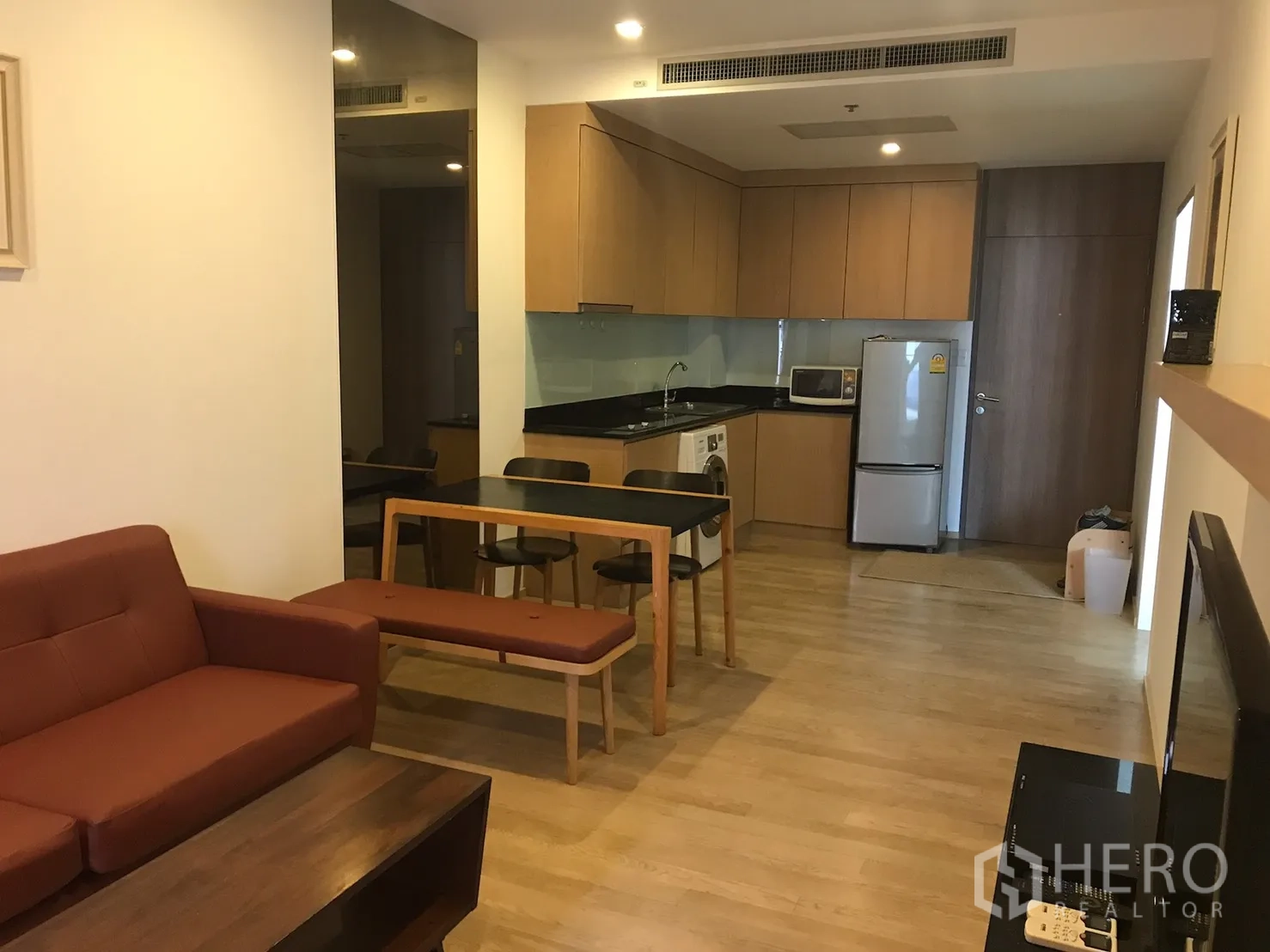 คอนโด ให้เช่าในBangkok - ห้องนั่งเล่นแปลนเปิดโล่ง มีโซฟา ชุดทานอาหาร และครัวบิวท์อินพร้อมเครื่องใช้ไฟฟ้า