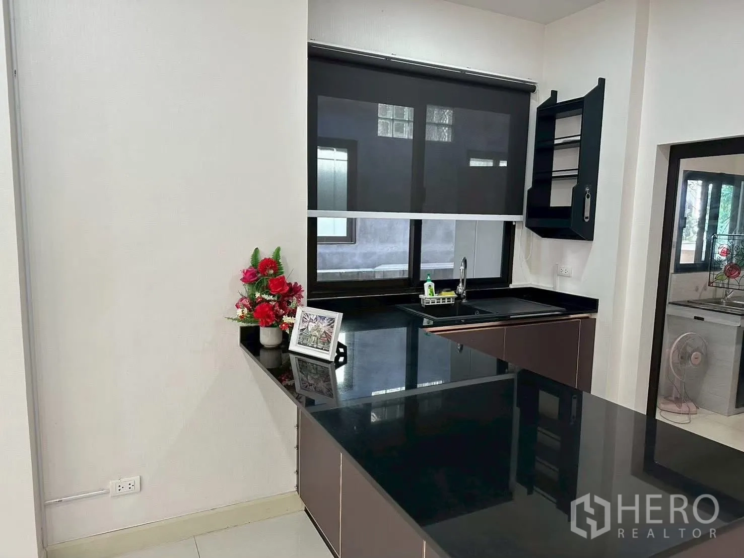独栋房屋 for rent in Bang Phli, Samut Prakan - 开放式厨房设黑色石材台面、窗下水槽与角落置物架。