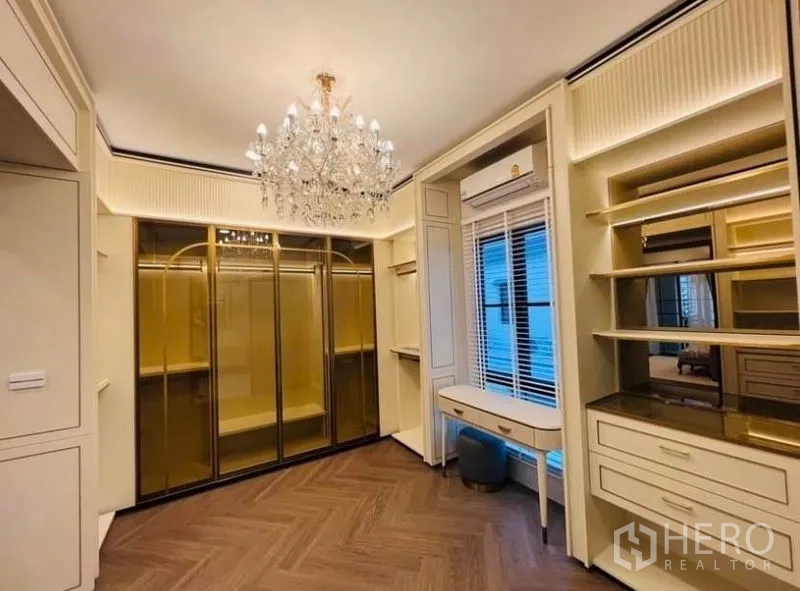 Detached House for rent or sale in Saphan Sung, Bangkok - Walk-in closet with custom cabinetry, mirrored doors and chandelier lighting.
