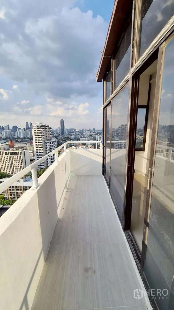 Condominium for rent in Watthana, Bangkok - Balcony corridor with glass wall and skyline outlook.