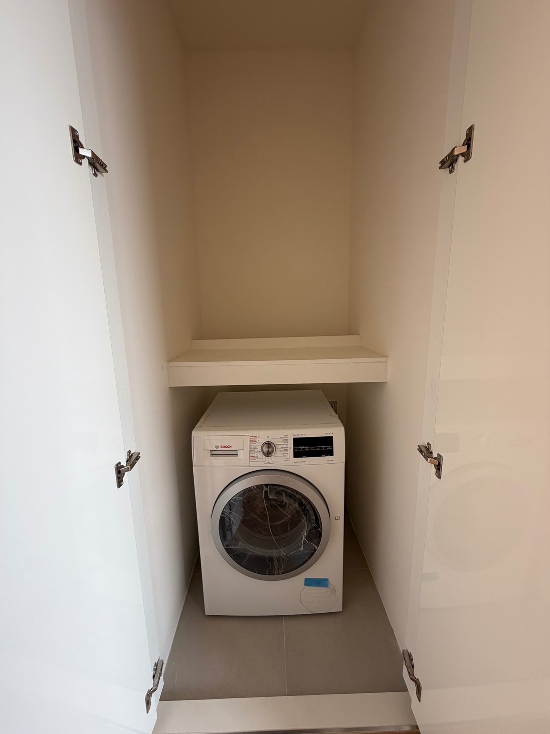 公寓 出租在Bang Rak, Bangkok - 内嵌柜体中的博世滚筒洗衣机，上方带储物层板。