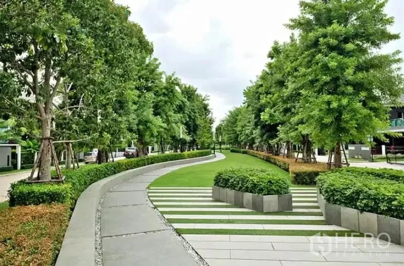 Detached House for sale in Bang Kapi, Bangkok - Central landscaped promenade with trees and patterned walkway in the estate.