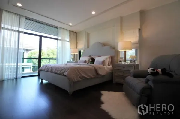 独立式住宅 出租在Prawet, Bangkok - 明亮主卧，特大床、大落地窗与阳台景观。