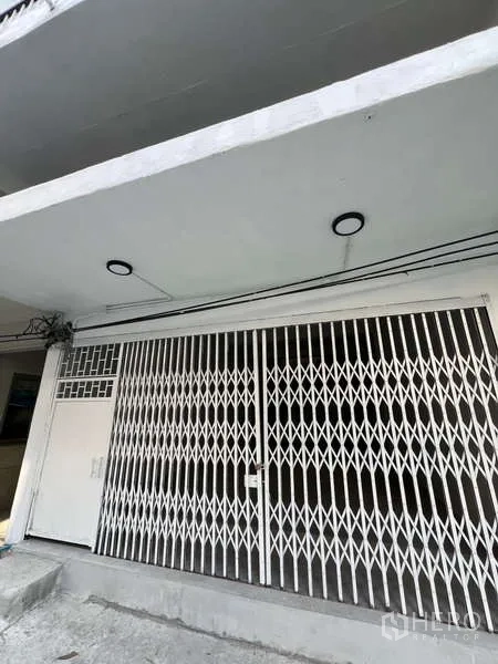 อาคารพาณิชย์ ให้เช่าในWatthana, Bangkok - ด้านหน้าตึกอาคารพาณิชย์ สีขาว พร้อมประตูเหล็กยืดและไฟฝ้า