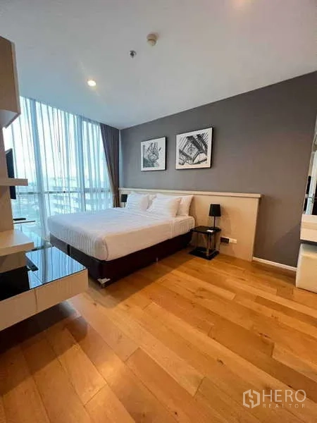 คอนโด ให้เช่า - ห้องนอนสว่าง พื้นไม้ เตียงขนาดใหญ่ ภาพตกแต่ง และผ้าม่านสูงจรดเพดาน