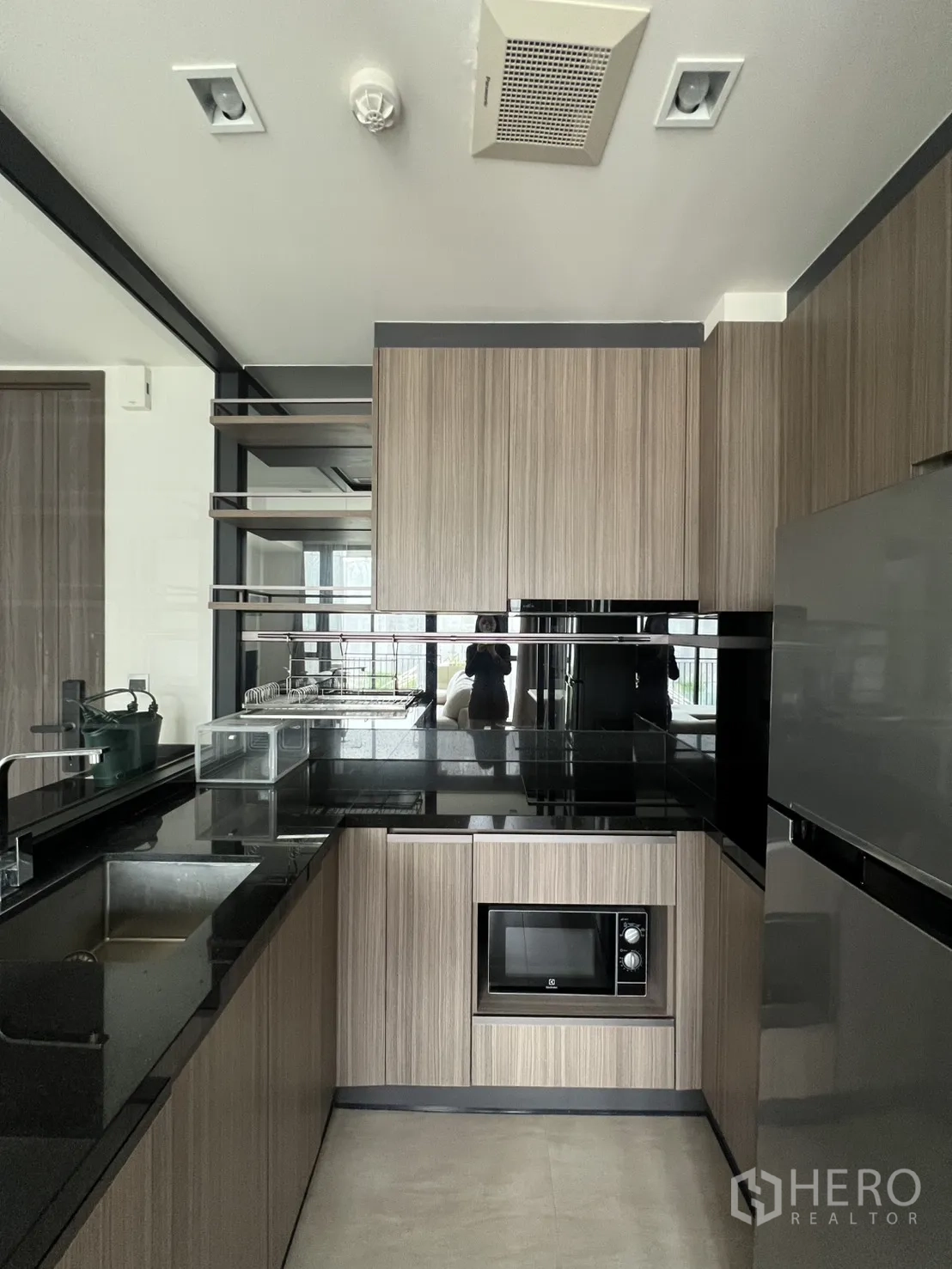 คอนโด for rent in Watthana, Bangkok - ครัวรูปตัวยูขนาดกะทัดรัด เคาน์เตอร์หินสีดำ อ่างล้างจาน ไมโครเวฟ ตู้และตู้เย็น