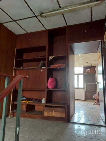 Shophouse for rent in Pom Prap Sattru Phai, Bangkok - Wall of built-in wooden cabinetry beside the stairwell for storage.
