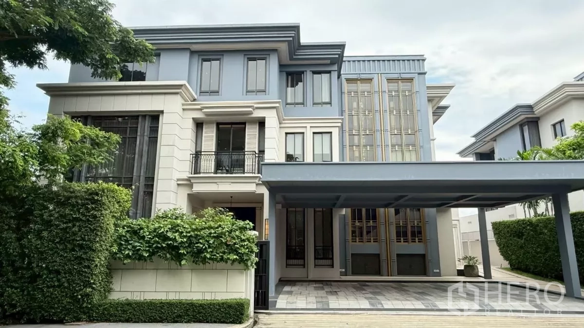 Detached House for sale in Saphan Sung, Bangkok - Three-storey luxury detached house facade with covered four-car carport, tall windows and lush hedges.