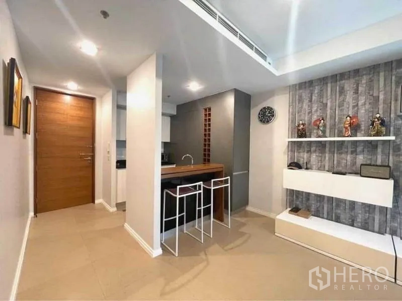 คอนโด ให้เช่าในKhlong San, Bangkok - โถงทางเข้าเชื่อมบาร์ทานข้าวพร้อมสตูลสองตัว และชั้นวางของติดผนังข้างครัว