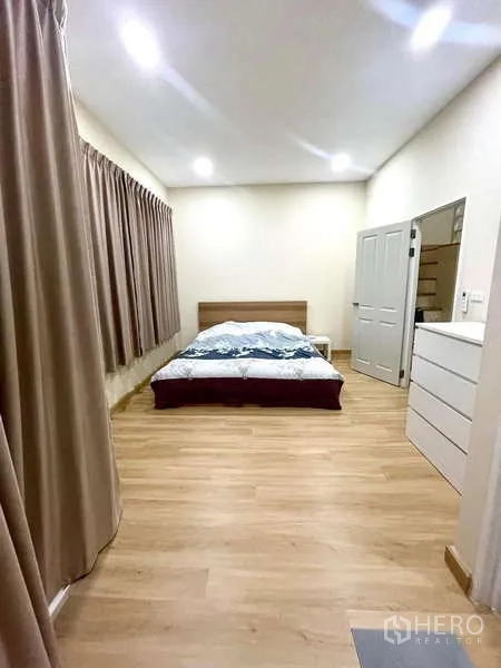 ทาวน์เฮาส์ ให้เช่าหรือขาย - ห้องนอนมาสเตอร์กว้าง มีเตียง หน้าต่างบานยาว และผ้าม่าน