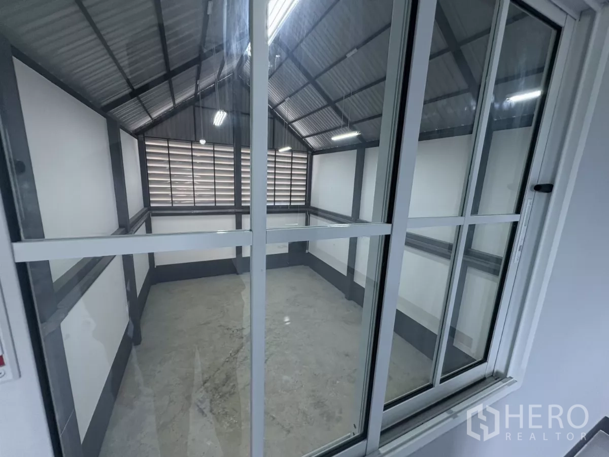 工厂 出租或出售在Bang Bua Thong, Nonthaburi - 玻璃封闭办公室，可俯瞰仓库作业区。