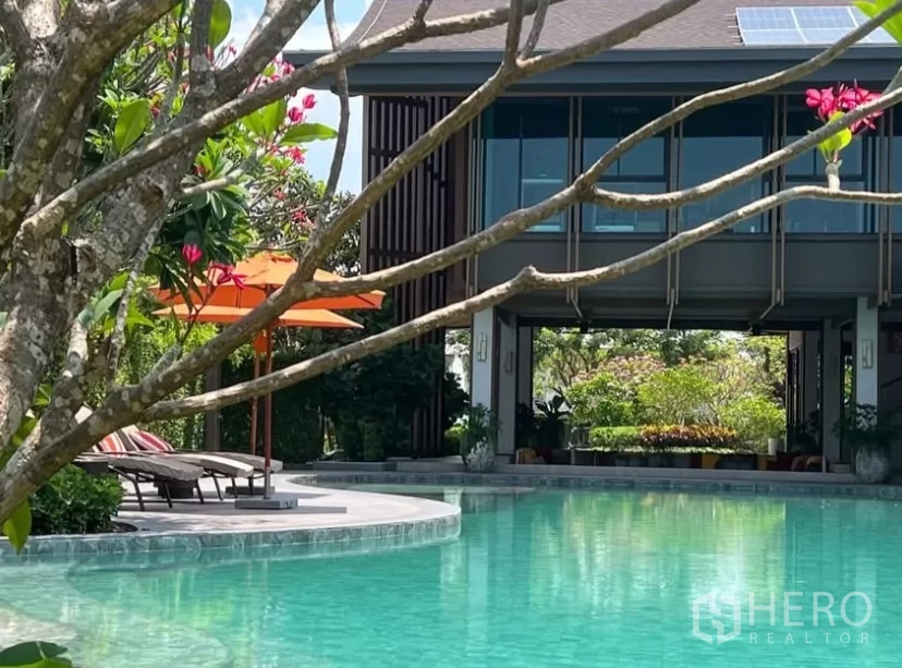 Detached House for rent or sale in Bang Kapi, Bangkok - Resort-style communal swimming pool with sun loungers and landscaped gardens.