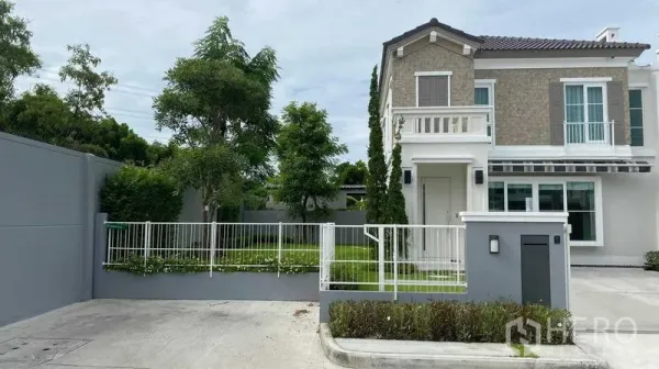 Detached House for rent or sale in Prawet, Bangkok - Front elevation of the detached home with balcony and gated parking.